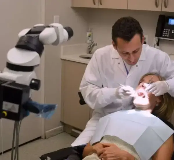 Dentist treating patient with microscope