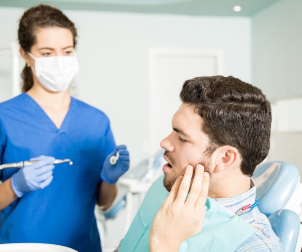 Man Experiencing Tooth Pain At Dentist